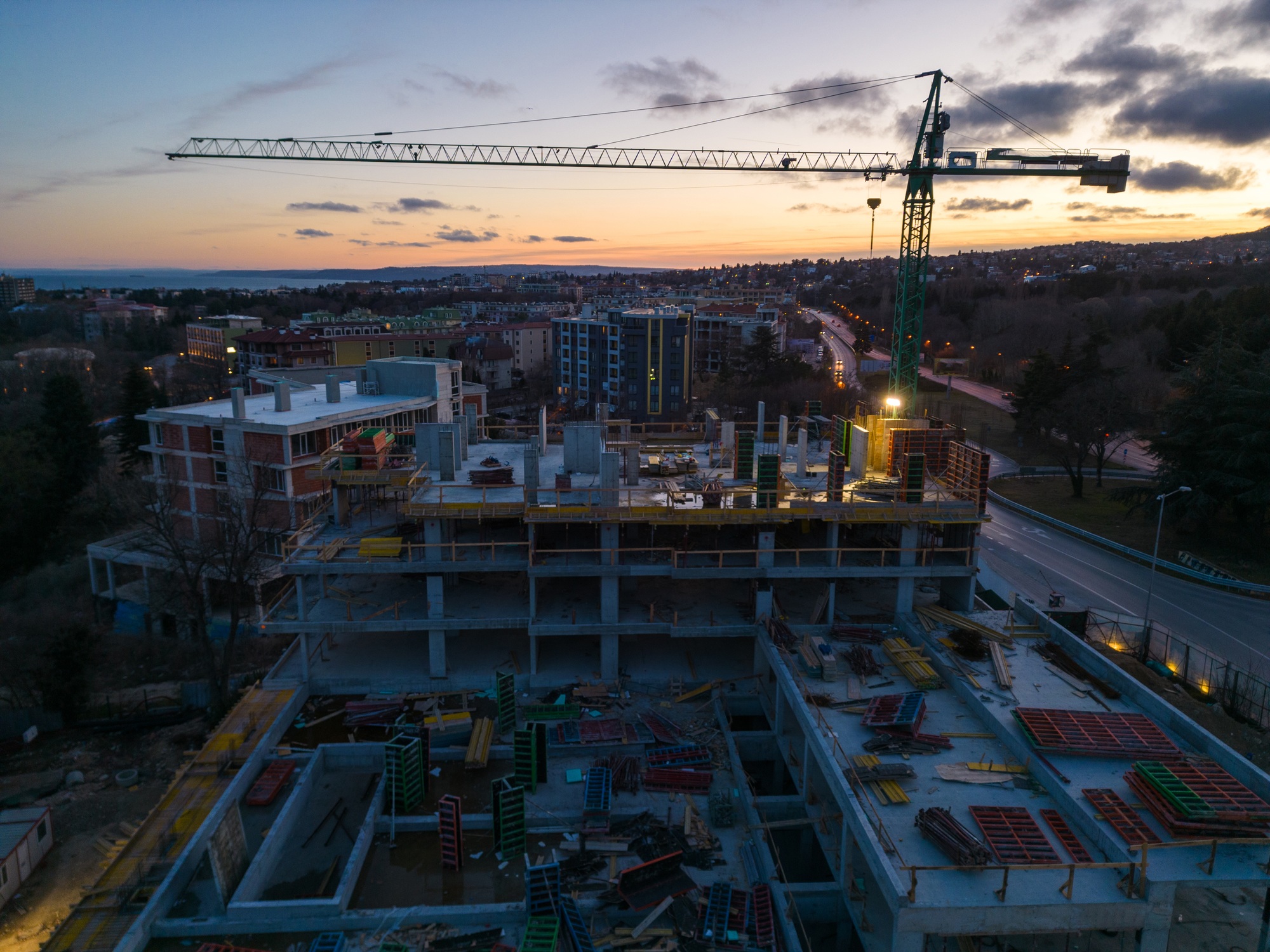 Busy Construction Site and Construction Equipment at night. Aerial view